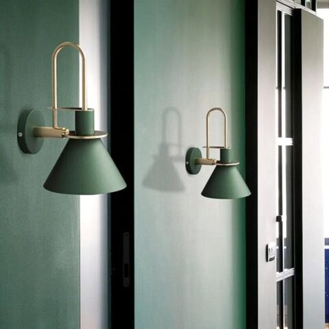 on voit un mur vert fondé et dessus deux appliques murales posées de couleur verte foncés dans le style scandinave