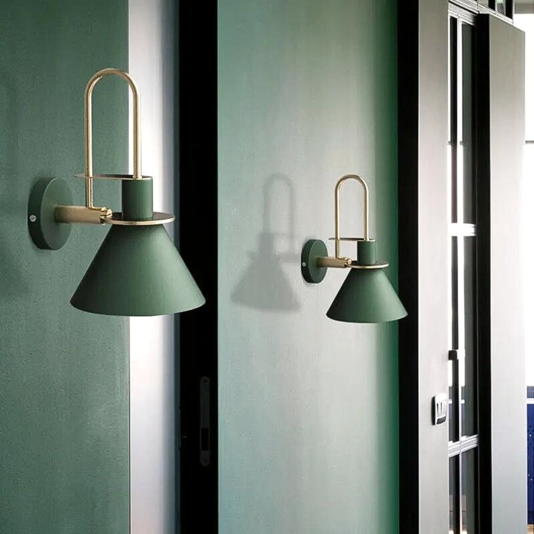 on voit un mur vert fondé et dessus deux appliques murales posées de couleur verte foncés dans le style scandinave