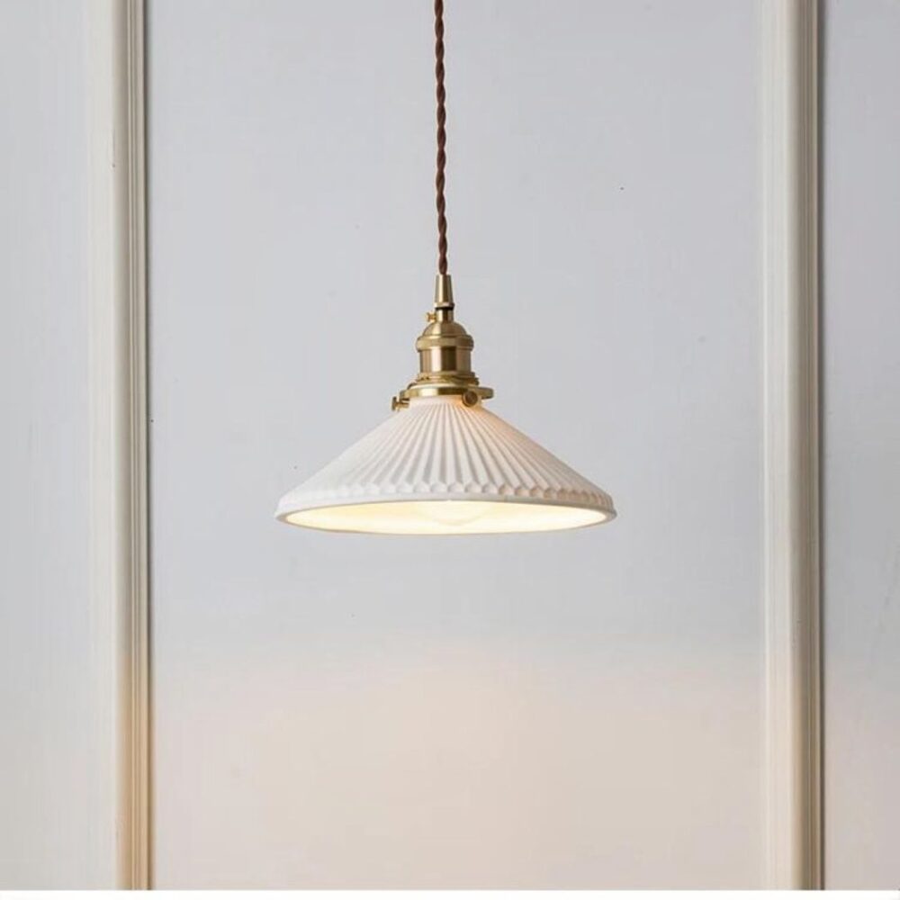 on voit sur un fond blanc une suspension en céramique blanche et en cuivre dans le style vintage