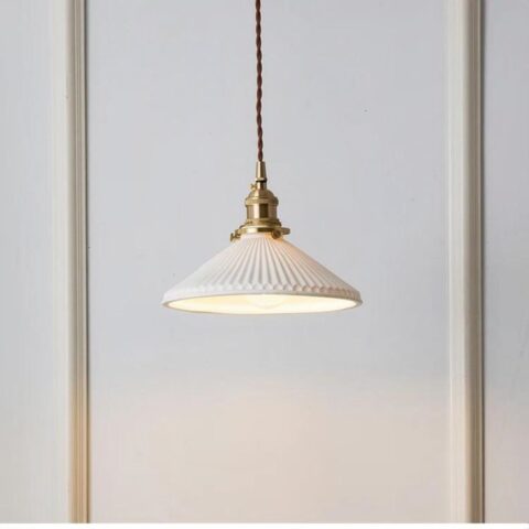 on voit sur un fond blanc une suspension en céramique blanche et en cuivre dans le style vintage