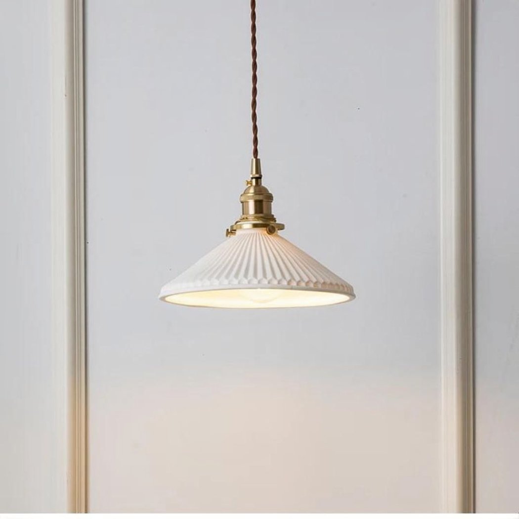 on voit sur un fond blanc une suspension en céramique blanche et en cuivre dans le style vintage