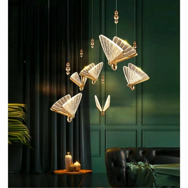 on voit dans un salon aux tons foncés marron vert une suspension dorée et transparente en forme de papillon
