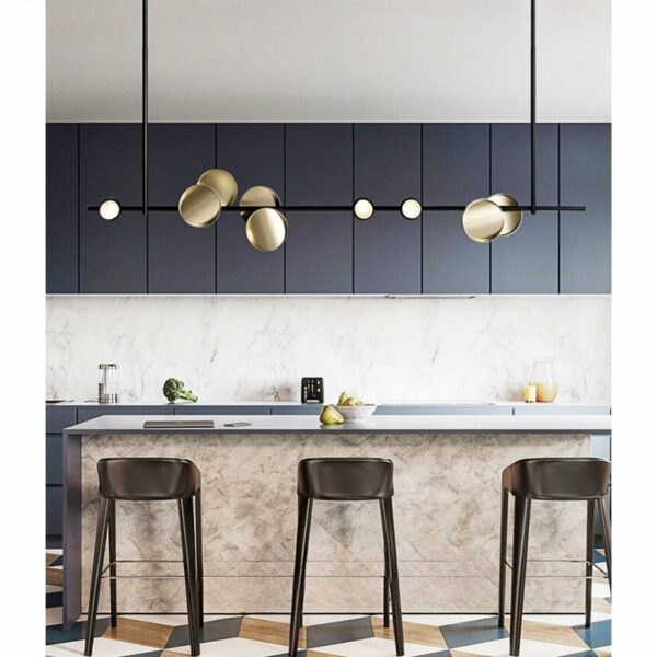 on voit dans une cuisine moderne une belle suspension scandinave noire minimaliste avec des cercles dorés au dessus du plan de travail