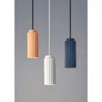 on voit sur un fond clair 3 suspensions de couleurs différentes blanche rose et bleu canard dans le style scandinave