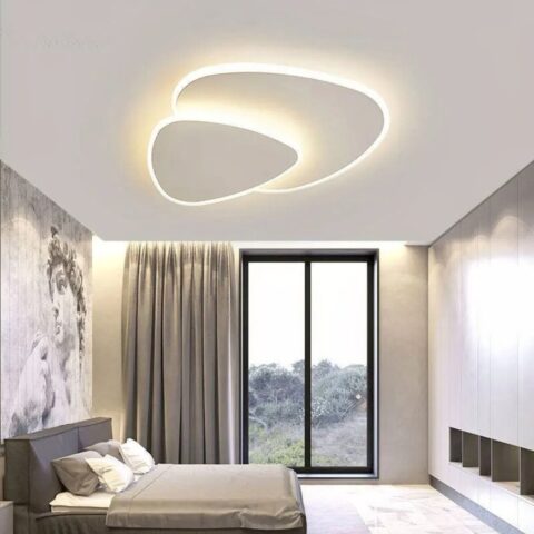 Lustre plafonnier moderne de salon en triangle design blanc fixé au plafond d'une chambre à coucher et allumé.