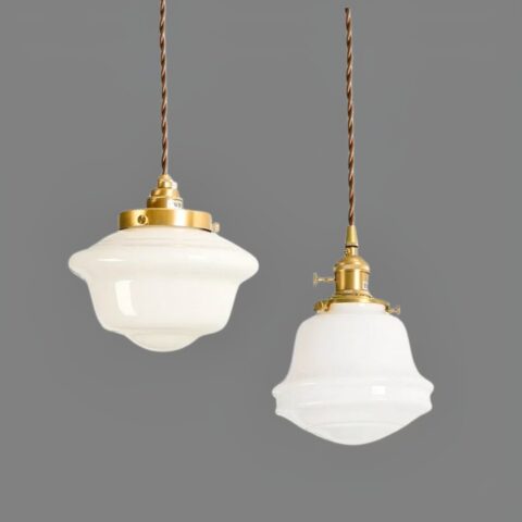 Suspension rustique en verre blanc style céramique dans ses deux versions et suspendues au plafond, sur fond gris foncé.