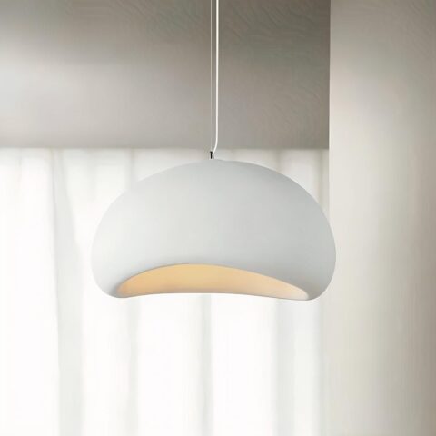 Lustre blanc en forme de dôme tenu par un câble blanc. En arrière-plan, un mur beige avec une fenêtre.
