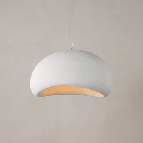 Lustre blanc en forme de dôme tenu par un câble blanc. En arrière-plan, un mur beige avec une fenêtre.