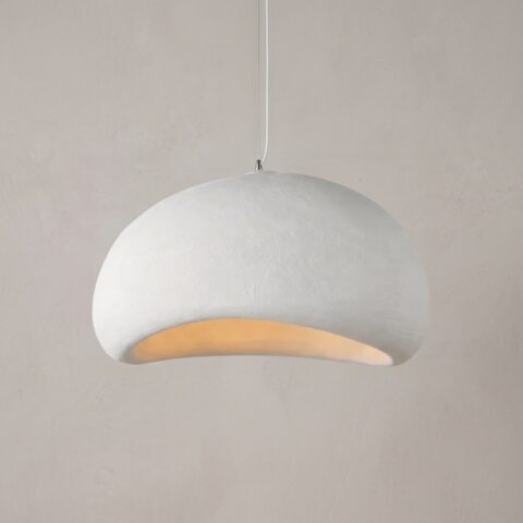 Lustre blanc en forme de dôme tenu par un câble blanc. En arrière-plan, un mur beige avec une fenêtre.
