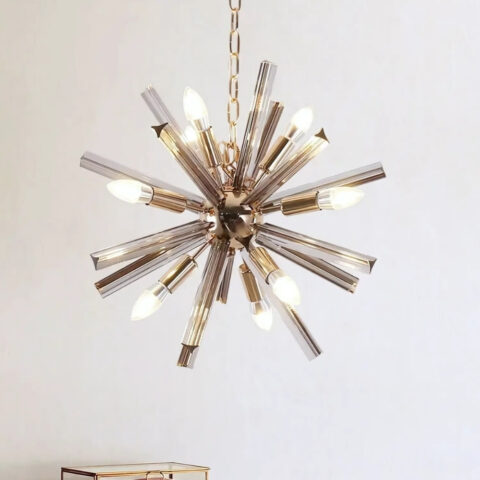 Lustre spoutnik avec tubes en cristal gris et plusieurs ampoules allumées suspendu par une chaine en métal.