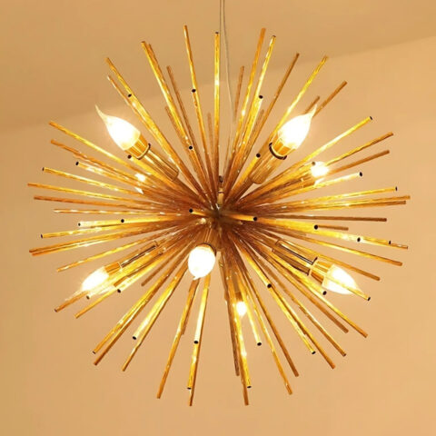 Lustre spoutink doré avec plusieurs ampoules allumées sur fond marron clair.