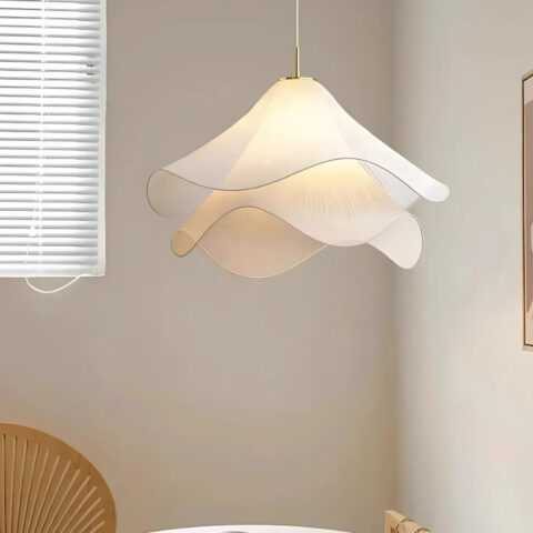 Suspension fleur délicate blanche en tissu allumée au-dessus d'une table avec une chaise et une fenêtre sur la gauche.