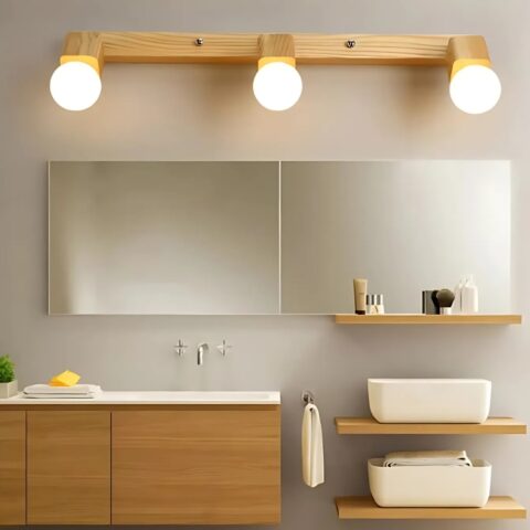 Applique murale en bois et métal avec trois lumières rondes, idéale pour éclairer une salle de bain de manière moderne et chaleureuse.