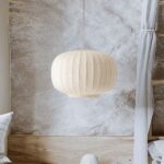 suspension blanche en forme de galet sculpté, en tissu plissé effet soie, suspendue dans un intérieur clair