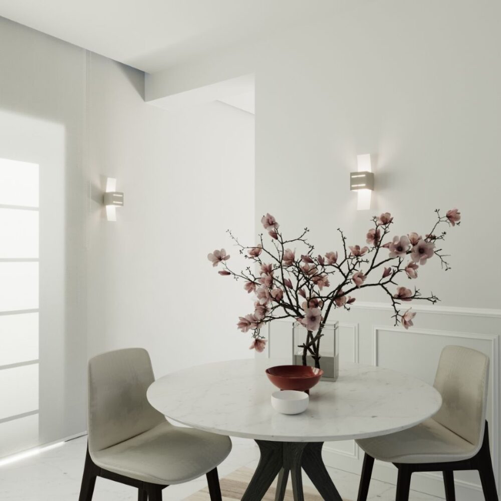 Deux appliques à ailes en verre encadrant une entrée avec table et fleurs