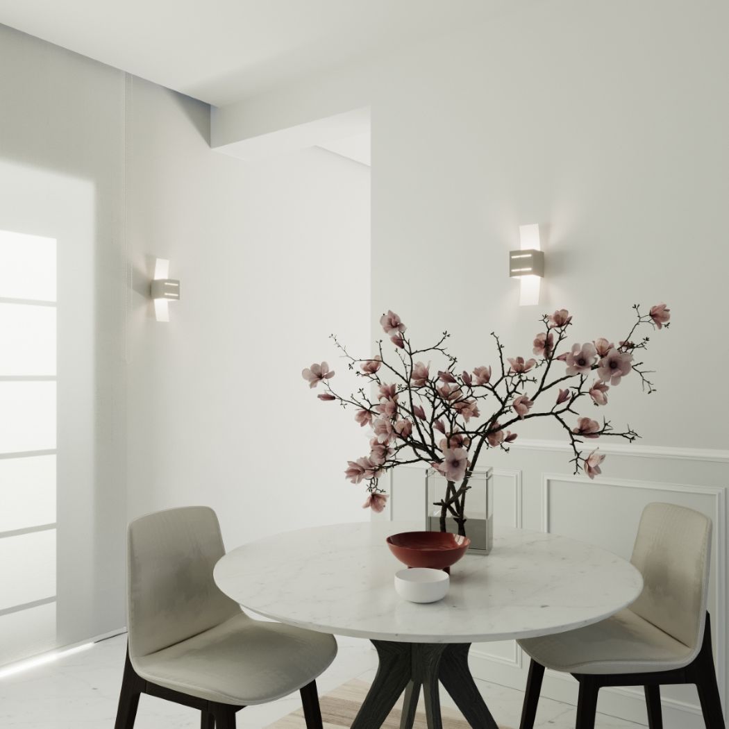 Deux appliques à ailes en verre encadrant une entrée avec table et fleurs