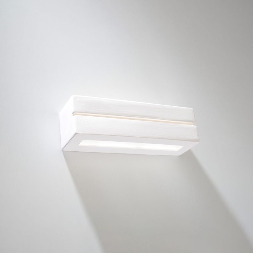 Applique murale en céramique blanche en forme de rectangle ajouré sur fond blanc