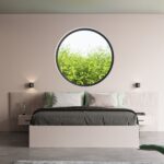 Chambre avec deux petites appliques rondes encadrant un lit sous une fenêtre ronde