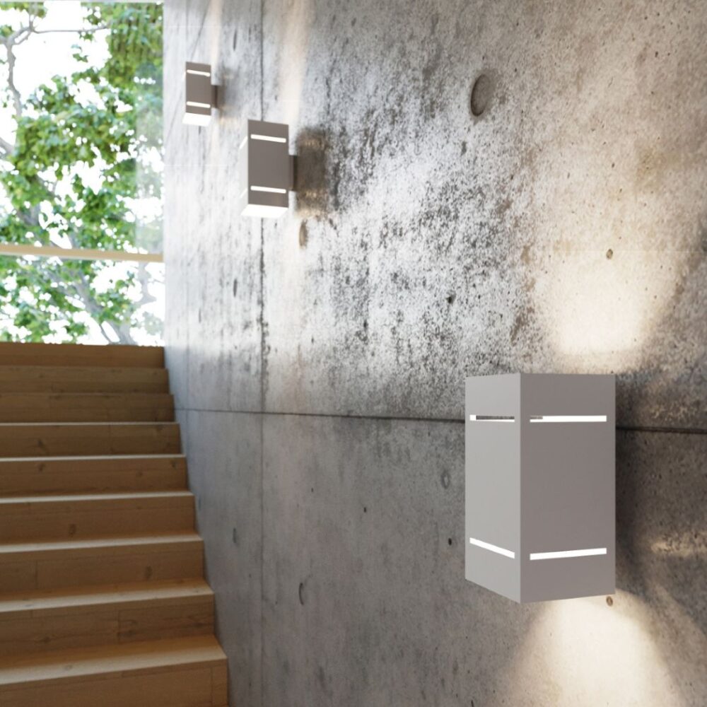 Applique rectangulaire en aluminium sur mur en béton près d'un escalier en bois et d'une baie vitrée
