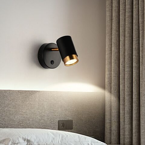 Applique murale spot noir sur un mur au dessus d'un lit