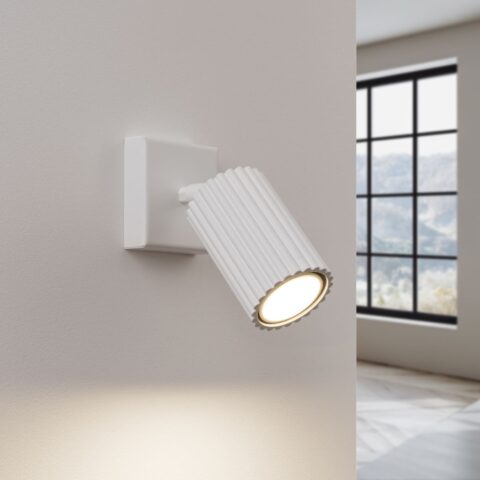 Applique murale spot moderne et élégante en métal blanc avec une texture nervurée dans un salon
