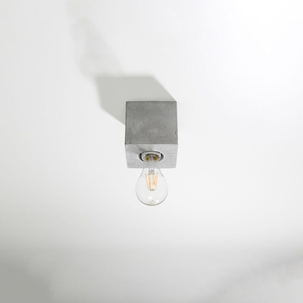 Lustre plafonnier carré en béton brut gris au style industriel sur fond gris blanc
