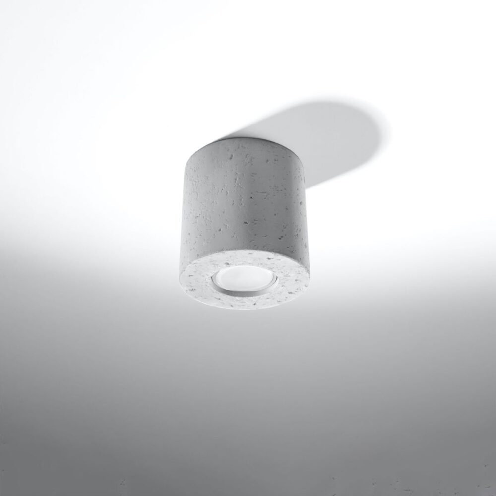 Lustre plafonnier rond en béton brut au style industriel sur fond gris blanc