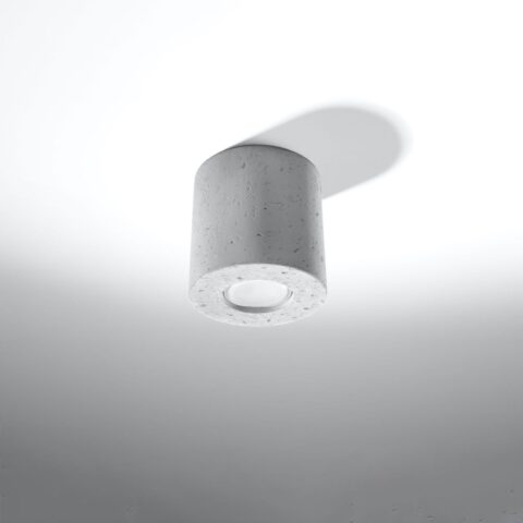 Lustre plafonnier rond en béton brut au style industriel sur fond gris blanc