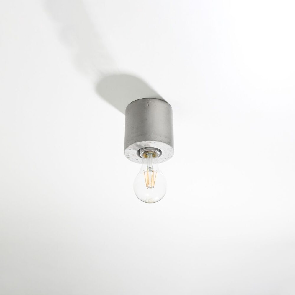 Lustre plafonnier rond au style industriel en béton gris sur fond gris blanc