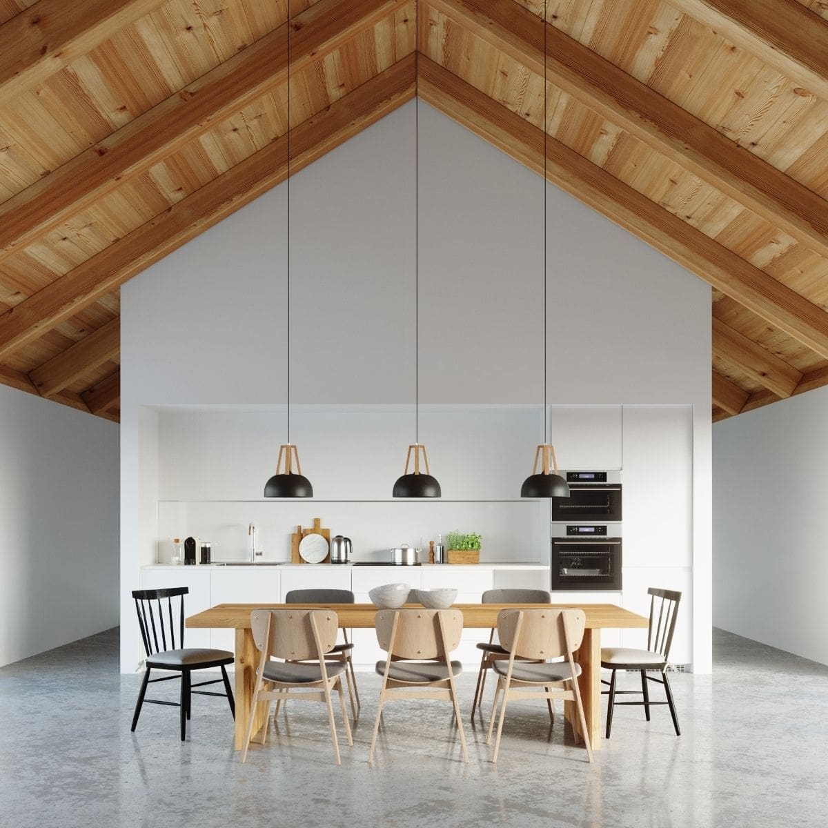 Trois suspensions noires à structure en bois au-dessus d'une table avec chaises noires