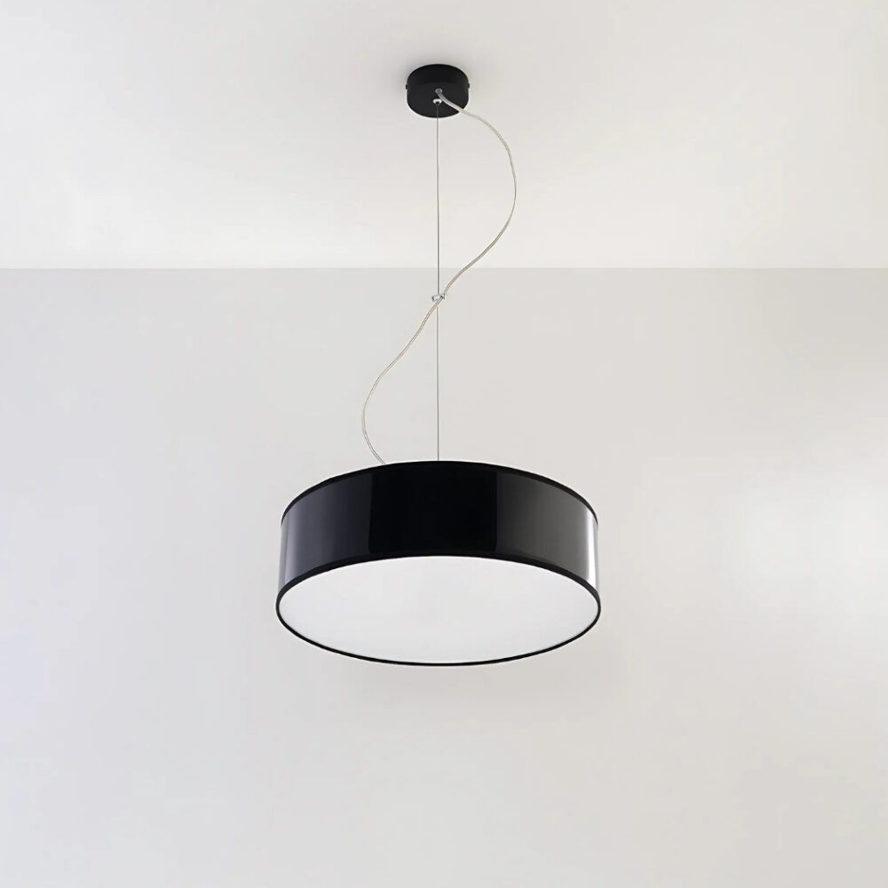 Lustre suspendu avec abat-jour rond en PVC de couleur noire suspendu sur un plafond blanc.