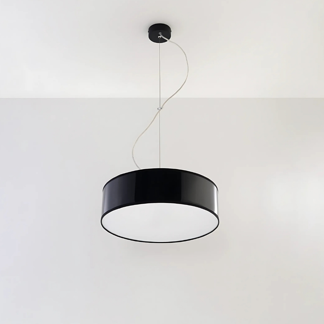 Lustre suspendu avec abat-jour rond en PVC de couleur noire suspendu sur un plafond blanc.