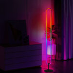 Lampadaire LED d’angle intelligent noir de forme ovale, doté d'une lumière RGB multicolore immersive, design minimaliste dans un salon moderne.