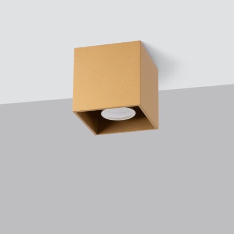 Lustre plafonnier cubique en aluminium doré fixé sur un plafond, design géométrique moderne et finition satinée sur fond gris.