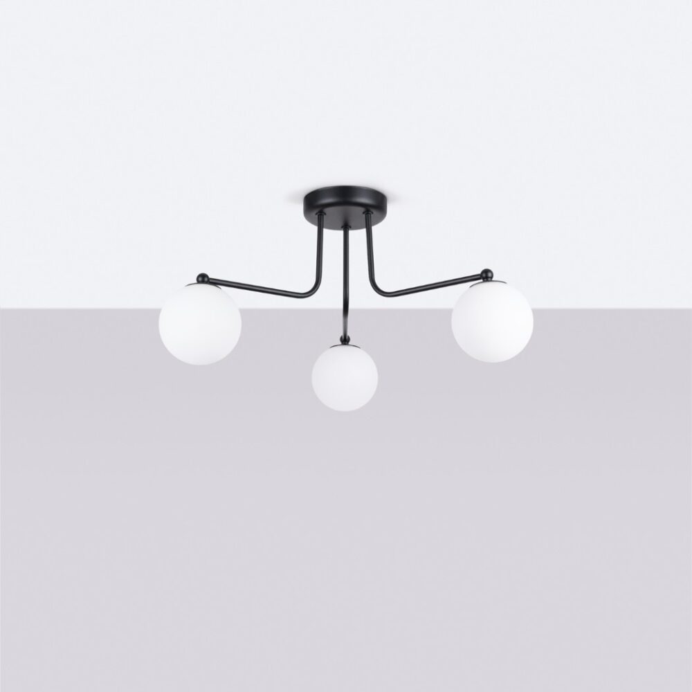 Lustre plafonnier moderne en métal noir avec globes en verre opalin intemporel, 3 abats jours sphérique sur plafond blanc et fond gris.