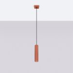 Suspension rouge ocre minimaliste tubulaire en aluminium au design moderne diffusant une lumière chaleureuse sur plafond blanc et fond gris.