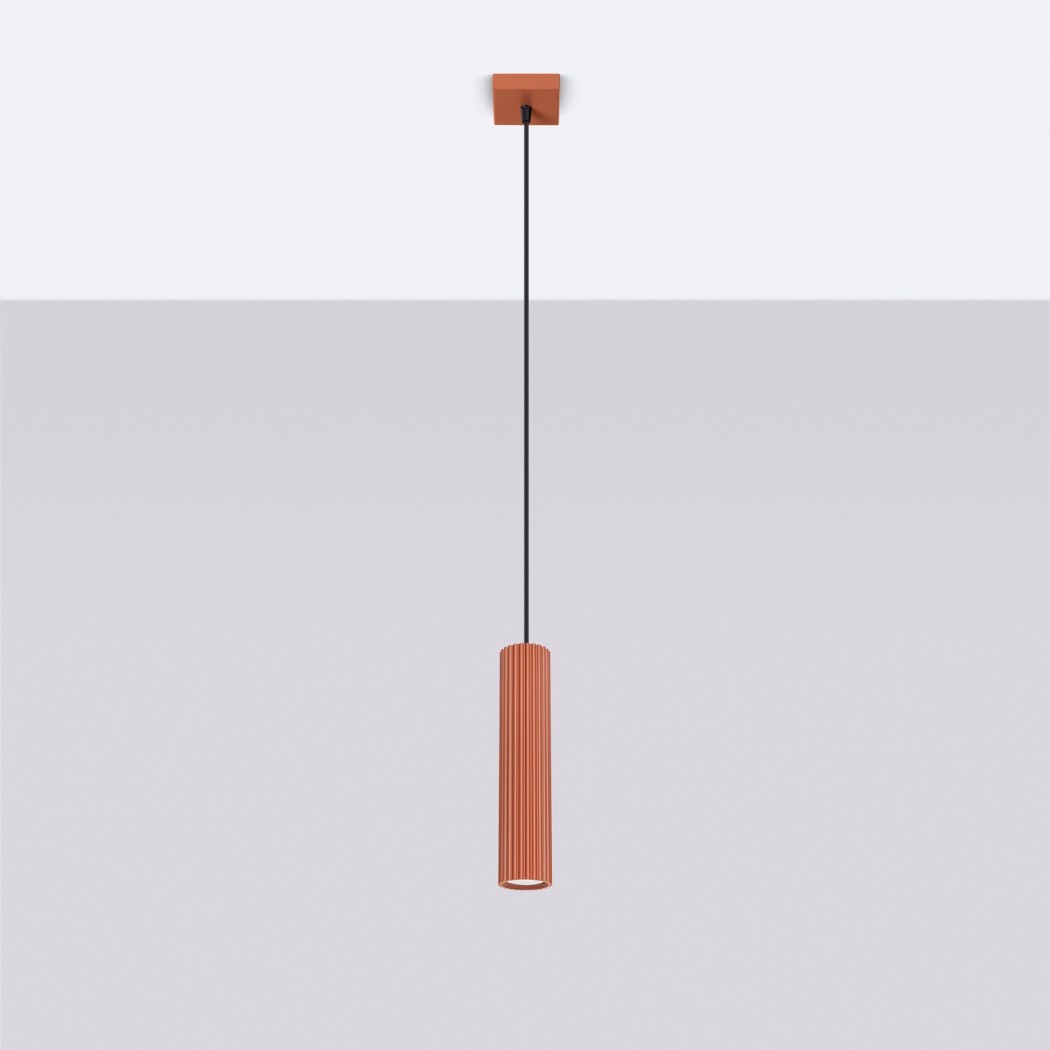 Suspension rouge ocre minimaliste tubulaire en aluminium au design moderne diffusant une lumière chaleureuse sur plafond blanc et fond gris.