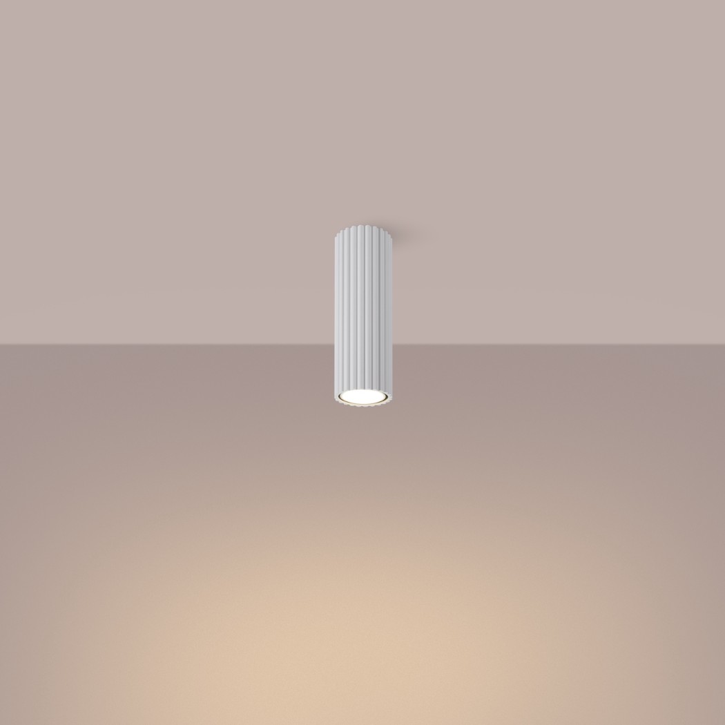 Plafonnier cylindrique cannelé vu de face sur un fond beige dégradé