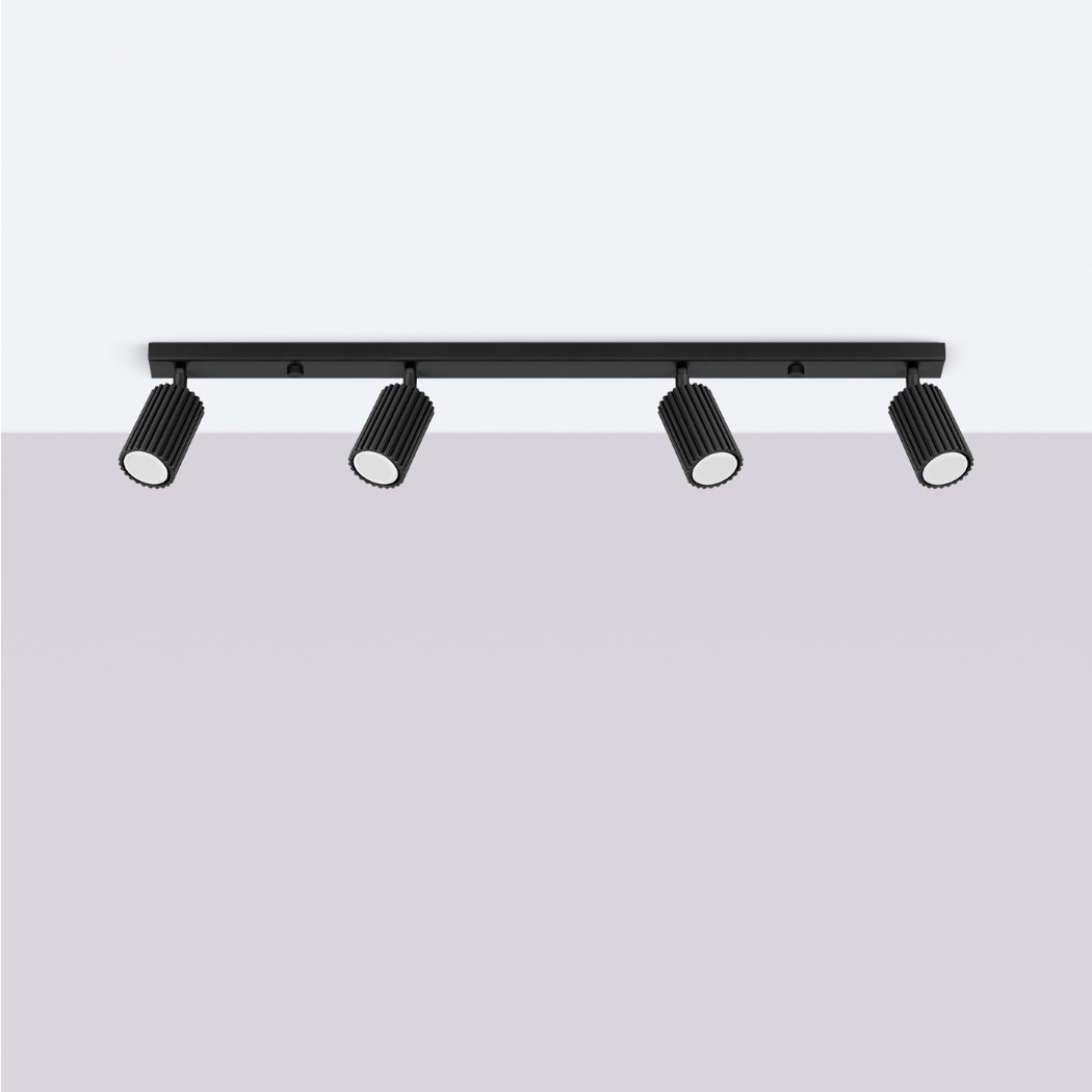 lustre plafonnier design à 4 spots orientables aluminium noir sur plafond blanc et fond gris.