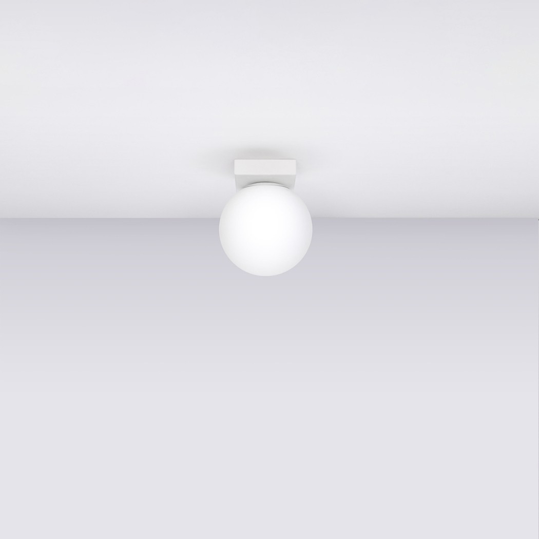 Lustre plafonnier blanc en forme de boule en verre au style minimaliste fixé au plafond blanc.