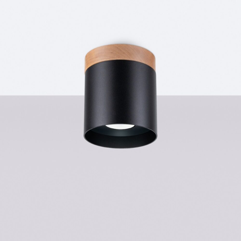 Lustre plafonnier noir en bois design scandinave de forme cylindrique sur plafond blanc et fond gris.