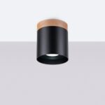Lustre plafonnier noir en bois design scandinave de forme cylindrique sur plafond blanc et fond gris.