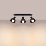 Barre noire à trois spots orientables allumés sur fond beige