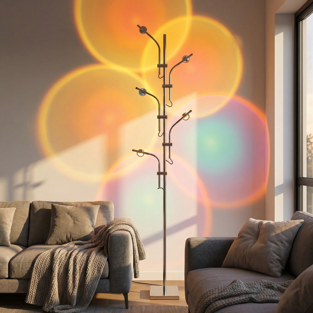 Un salon cosy baigné par la lumière du lampadaire halo sunset 7 couleurs ambiance romantique, projetant de grands halos orange, rose et bleu sur le mur.