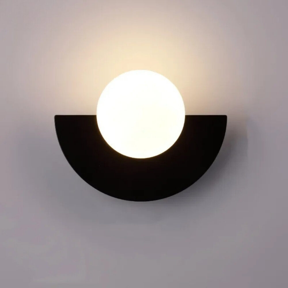 Applique murale design et élégante en métal noir et avec une ampoule globe, sur un mur gris