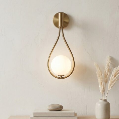 Applique murale style moderne en forme de goutte avec support métallique et globe en verre teinté diffusant une lumière douce, luminaire élégant fixé sur un mur intérieur.