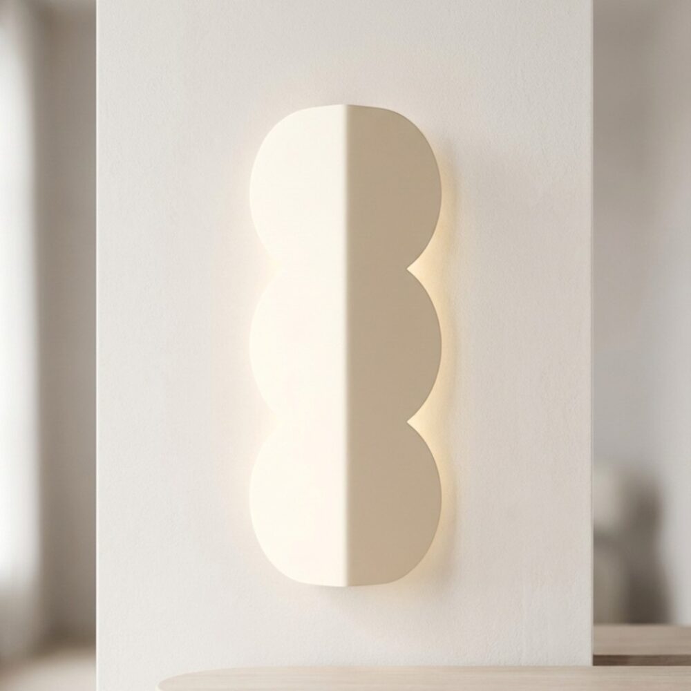 Notre applique murale forme biscuit beige en aluminium diffusant un lumière douce.