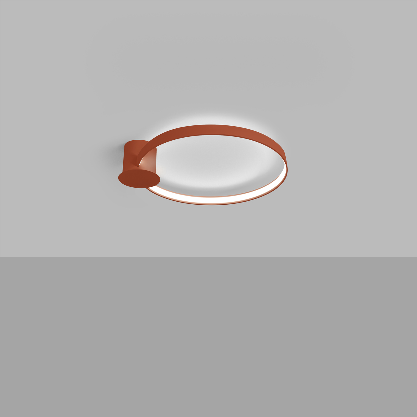 Le lustre plafonnier anneau LED ton chaud terracotta sur un plafond gris clair.