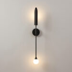 Applique murale design en métal noir avec 2 sources lumineuses, sur un mur gris