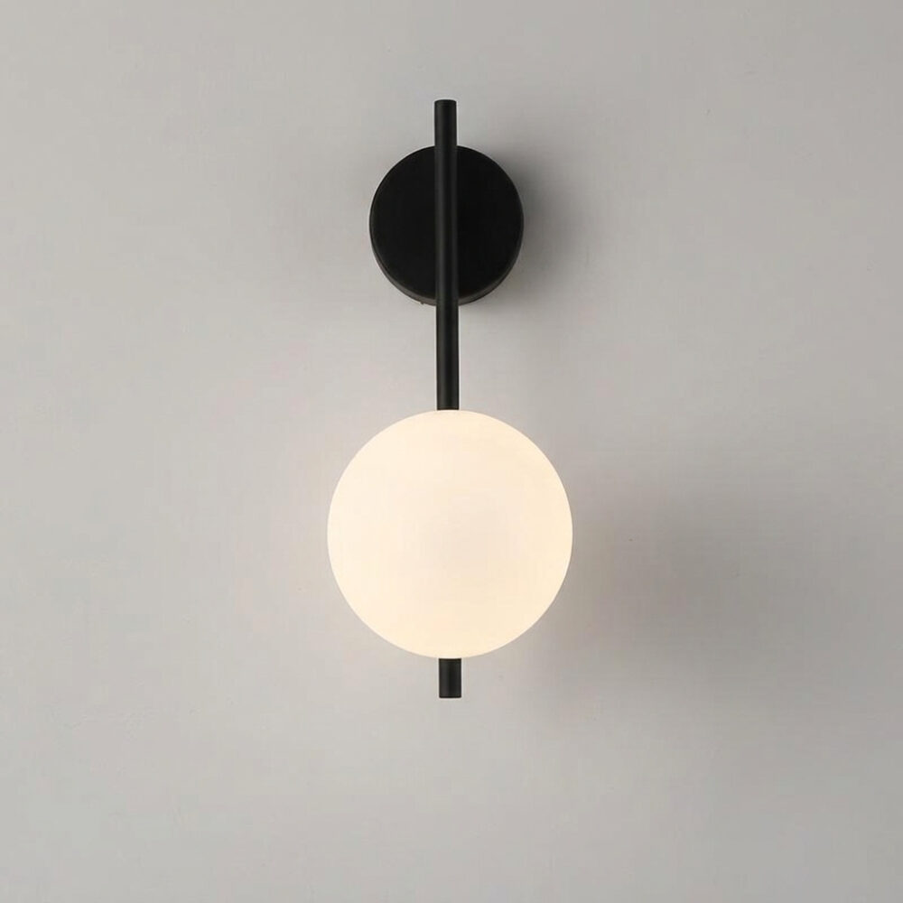 Applique murale moderne et minimaliste avec une tige en métal noir et un globe en verre dépoli, sur fond gris
